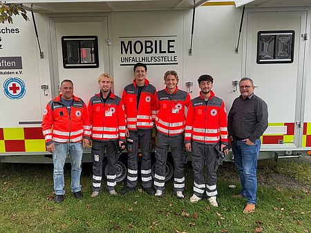 Mehrere DRK-Mitarbeiter vor einem Wagen "Mobile Unfallstelle"